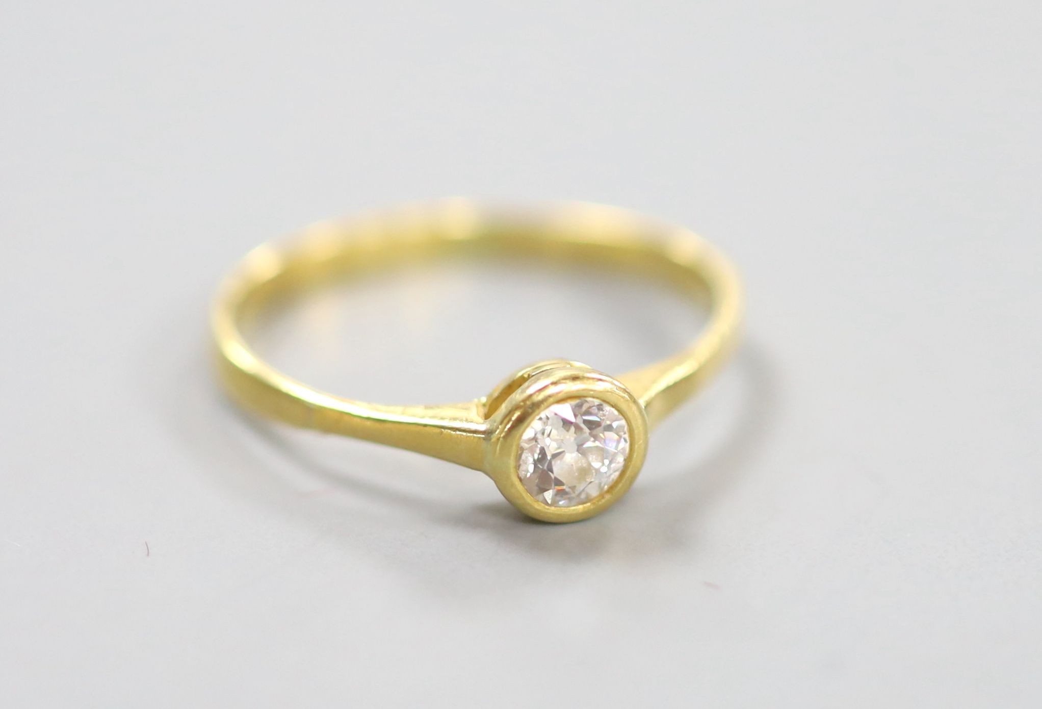 A yellow metal and collet set solitaire diamond ring, size P, gross weight 1.9 grams